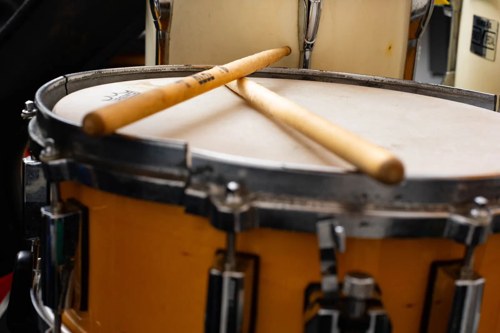 Snare drum with sticks resting on the head.